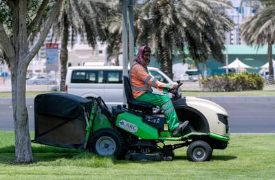 Abu Dhabi, United Arab Emirates, July 15, 2019.  Standalone weather images.   A AUH Municipality worker cuts the grass in front of the Abu Dhabi Central Bus Station.Victor Besa/The NationalSection:  NAReporter: