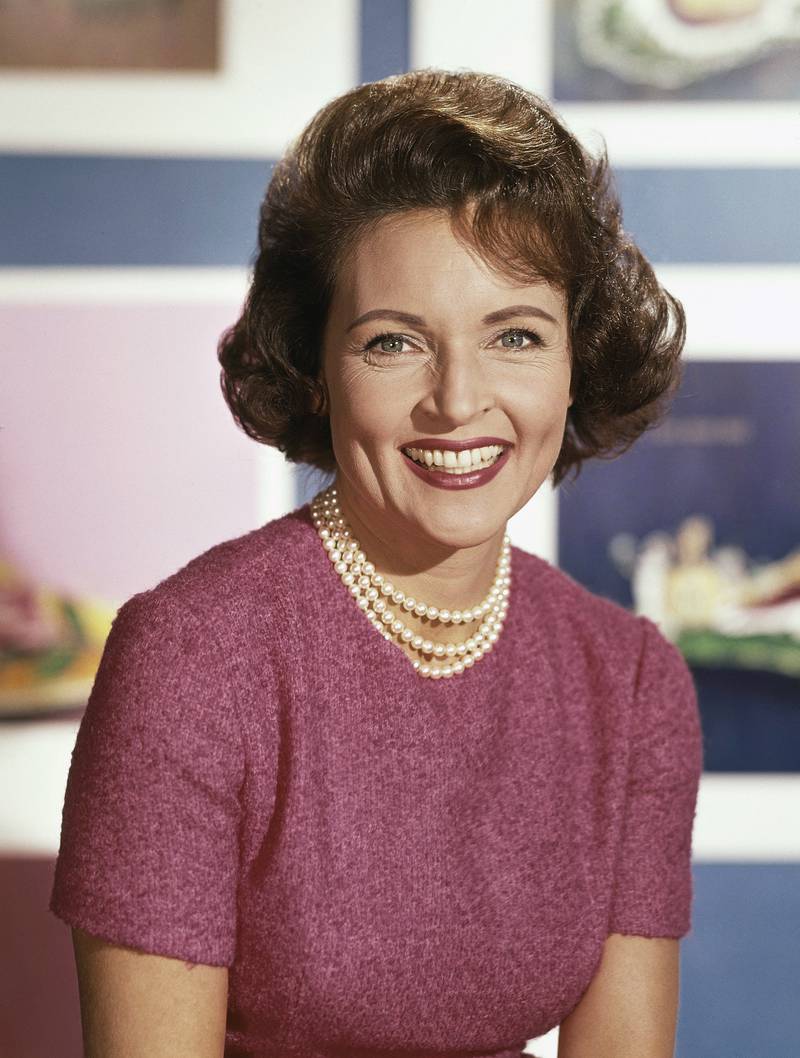 Betty White, in a dusty rose top and strings of pearls, poses for a headshot in 1965. AP