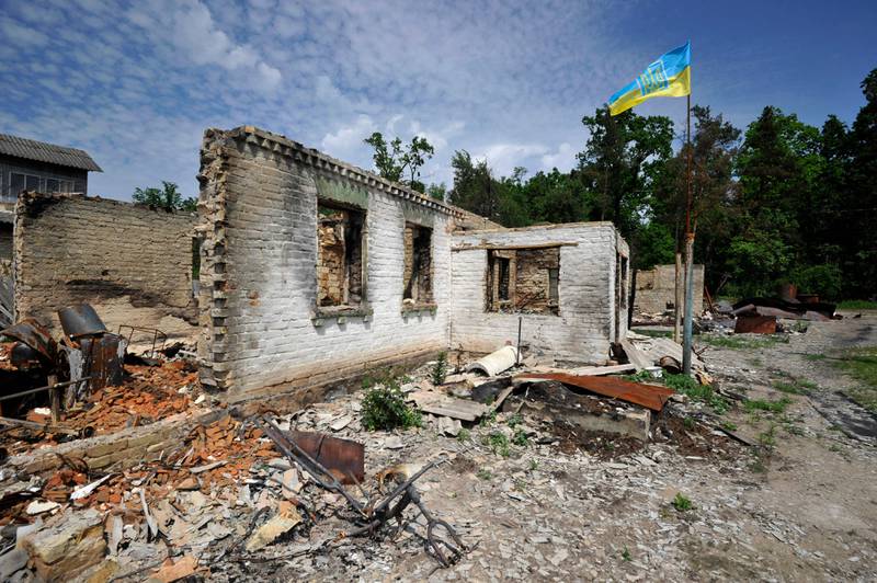 A Ukrainian flag waves over a house destroyed by shelling in the village of Moshchun, near Kyiv. AFP