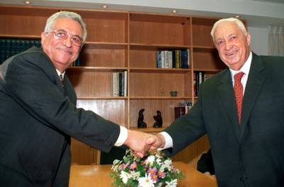 Mahmoud Abbas (L), the Palestinian negotiator better known as Abu Mazen, and Israeli Foreign Minister Ariel Sharon turn to the cameras and smile as they shake hands at the start of their meeting in Sharon's office November 18. The two met to review the work of all the Israeli-Palestinian peace committees and to set a date for the resumption of final status talks.

DPS/KM
