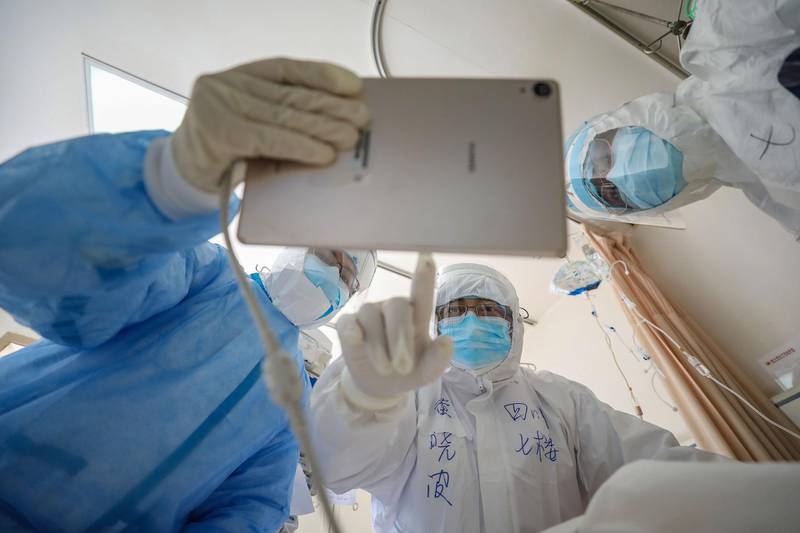 A doctor looking at an image as he checks a patient who is infected by the coronavirus at the Wuhan Red Cross Hospital in Wuhan. AFP