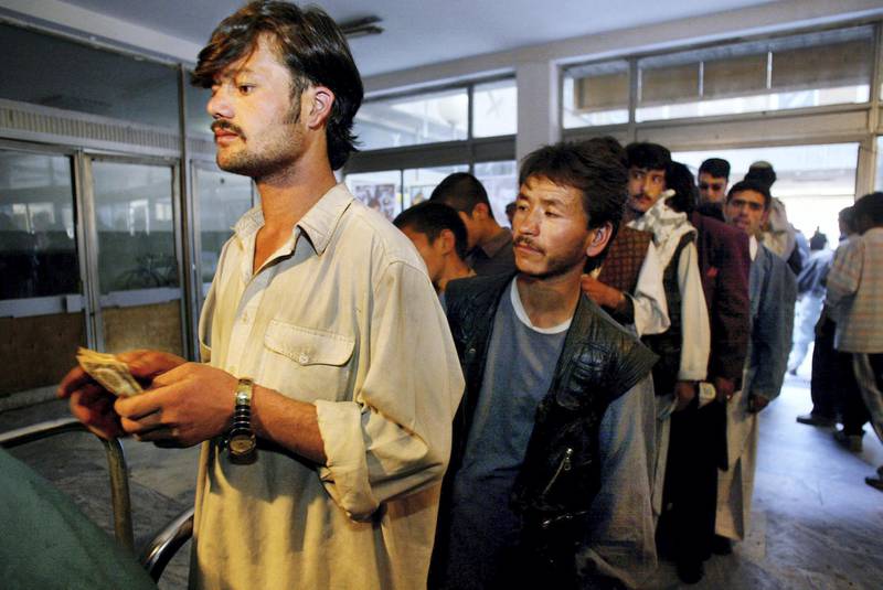 KABUL,  AFGHANISTAN - OCTOBER 14:   Afghan men wait in line to buy tickets for a movie at he Park Cinema October14,2002 in Kabul, Afghanistan. Tickets cost around 10 cents (8,000 Afghani). Only men are allowed to go and see the popular Indian Bollywood films.  (Photo by Paula Bronstein/Getty Images)