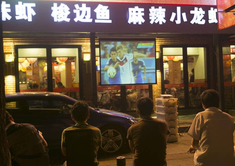 Chinese football fans watch a broadcast of the Fifa World Cup 2014 final. The governing body has extended the rights for CCTV to cover the next two events. Rolex Dela Pena/ EPA