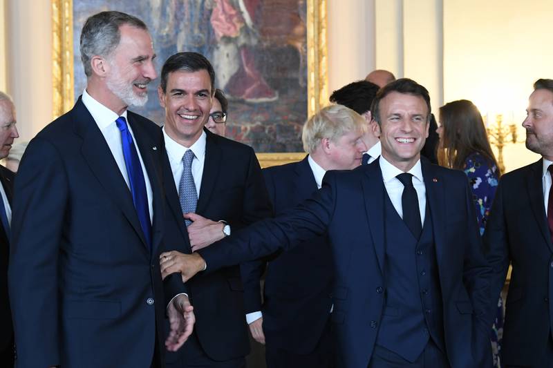 King Felipe VI, left, Mr Sanchez, second left and Mr Macron before the dinner. AP