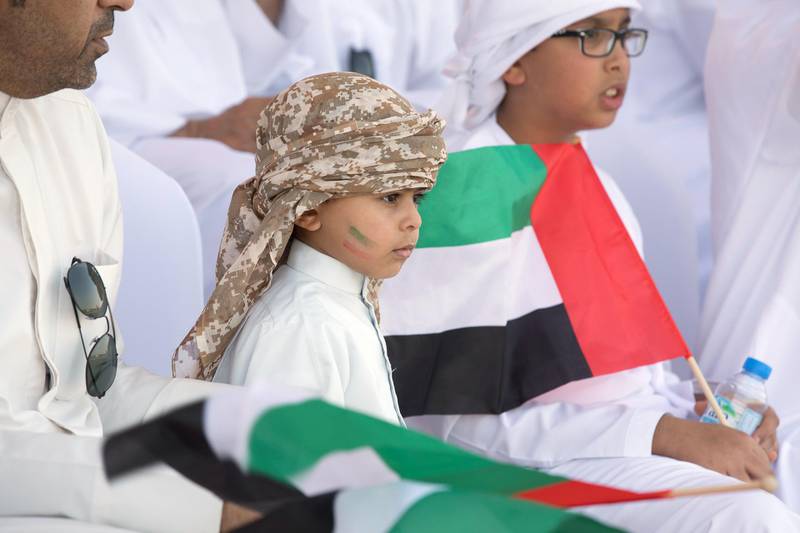 ZAYED MILITARY CITY, ABU DHABI, UNITED ARAB EMIRATES - November 28, 2017: A young guest watches the parade during the graduation ceremony of the 8th cohort of National Service recruits and the 6th cohort of National Service volunteers at Zayed Military City. 

( Boris Dejanovic for the Crown Prince Court - Abu Dhabi  )
---