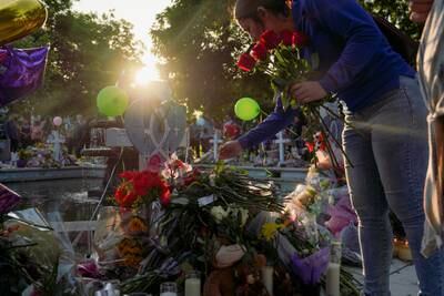 A woman places a rose on Layla Salazar’s memorial cross, who was one of the victims that died in the shooting. Reuters