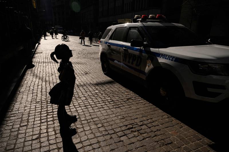 A police car passes a sculpture entitled 'Fearless Girl' outside the New York Stock Exchange (NYSE) in New York in January.  AFP