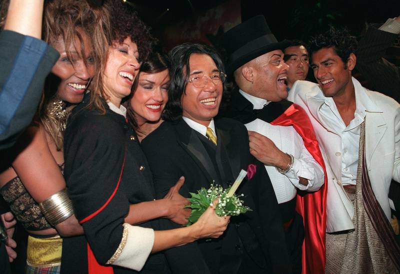Fashion designer Kenzo, centre, surrounded by models, after showing his final collection on October 7, 1999. AFP