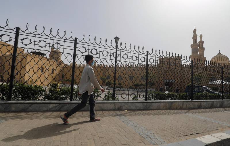 A man wearing a protective mask walks in front of closed Al-Azhar Mosque, as Egypt shut down mosques due to the spread of coronavirus disease (COVID-19), in Cairo, Egypt March 31, 2020. REUTERS/Amr Abdallah Dalsh
