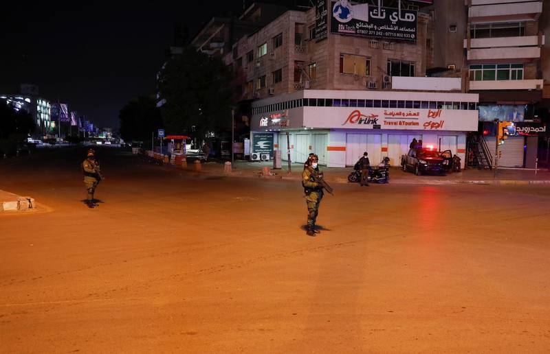 Iraqi security forces stand guard during a Covid-19 curfew in Baghdad, Iraq. REUTERS