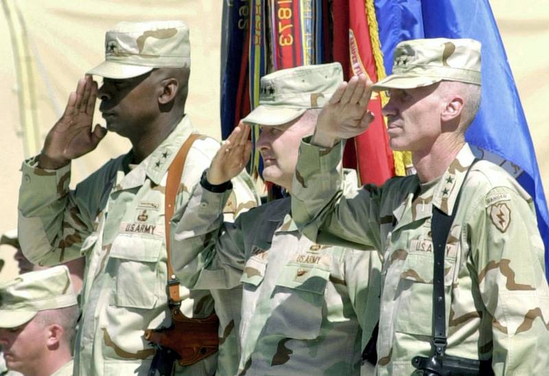 Commander of the U.S 25th Infantry Division Major General Eric T. Olson (R), Major General Lloyd Austin, commander of 10th Mountain Division (L) and US commander General David Barno (C) salute during a ceremony marking the change of authority from the 10th Montain Division to the newly arrived 25th Infantry Division at the coalition's Bagram Air Base headquarters north of Kabul, 15 April 2004. "I am very reluctant to predict any kind of time-line for the capture of any HVT (high value target) but I will say it is the highest priority," Major General Eric Olson, commander of 25th Infantry Division told reporters at the coalition's Bagram Air Base headquarters north of Kabul. AFP PHOTO/SHAH Marai (Photo by SHAH MARAI / AFP)