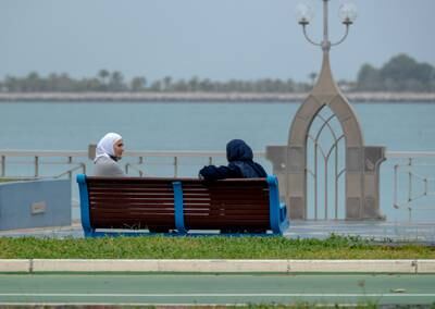 Two women enjoy a cool morning on the Corniche. Victor Besa / The National