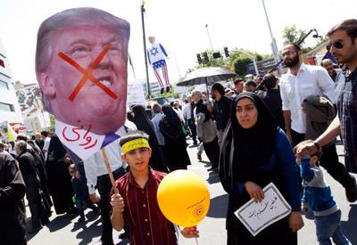 epa06792928 An Iranian boy hold a poster of US President Donald Trump with a hand writing on it which reads in Persian 'Crazy' during an anti-Israel rally marking Al Quds Day (Jerusalem Day), in support of Palestinian resistance against Israeli occupation, in Tehran, Iran, 08 June 2018. Each year Iran marks the last Friday of the fasting month of Ramadan as a solidarity day with the Palestinians.  EPA/ABEDIN TAHERKENAREH