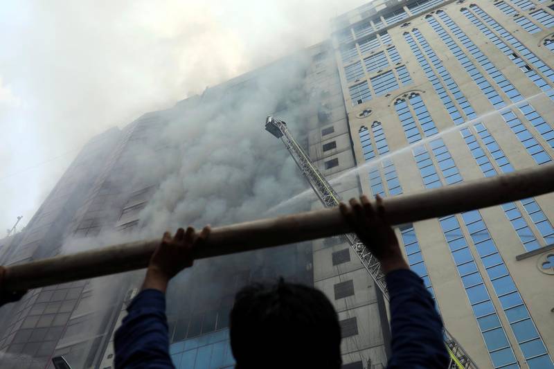 A person looks on as firefighters attempt to extinguish the fire. Reuters