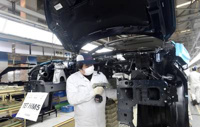 In this March 28, 2020 photo, a worker wearing a face mask works on an assembly line at a Dongfeng Honda automotive manufacturing plant in Wuhan in central China's Hubei Province. China's manufacturing rebounded in March as authorities relaxed anti-disease controls and allowed factories to reopen, an official survey showed Tuesday, but an industry group warned the economy has yet to fully recover. (Chinatopix via AP)