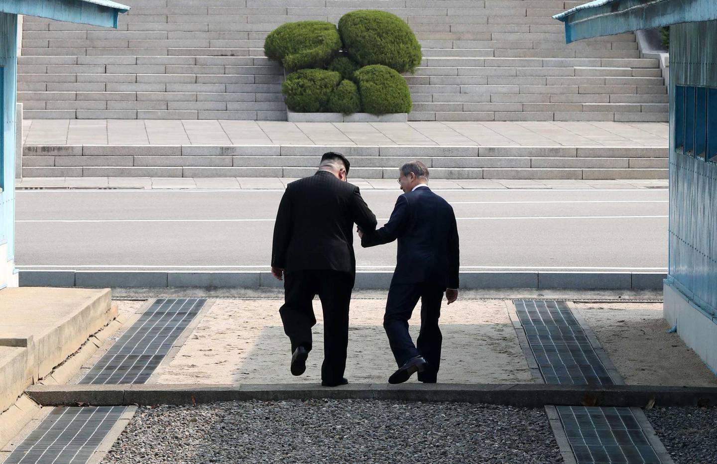 epaselect epa06695554 South Korean President Moon Jae-in (R) and North Korean leader Kim Jong-un (L) hold hands as they cross the military demarcation line (MDL) at the Joint Security Area (JSA) on the Demilitarized Zone (DMZ) in the border village of Panmunjom in Paju, South Korea, 27 April 2018. South Korean President Moon Jae-in and North Korean leader Kim Jong-un are meeting at the Peace House in Panmunjom for an inter-Korean summit. The event marks the first time a North Korean leader has crossed the border into South Korea sine the end of hostilities during the Korean War.  EPA/KOREA SUMMIT PRESS POOL / POOL
