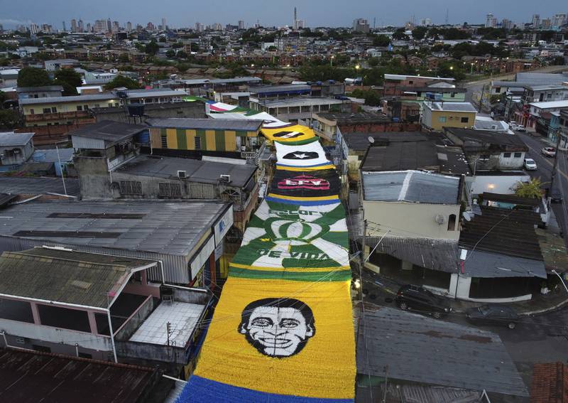 Seen from above, an image of soccer star Pele made from plastic ribbons decorates a street, amid other soccer related symbols, during the World Cup hosted by Qatar, in the Morro da Liberdade neighborhood of Manaus in Amazonas state, Brazil, early Monday, Dec.  5, 2022.  Pele has been in the hospital since Tuesday and officials say he is responding well to treatment for a respiratory infection.  (AP Photo / Edmar Barros)
