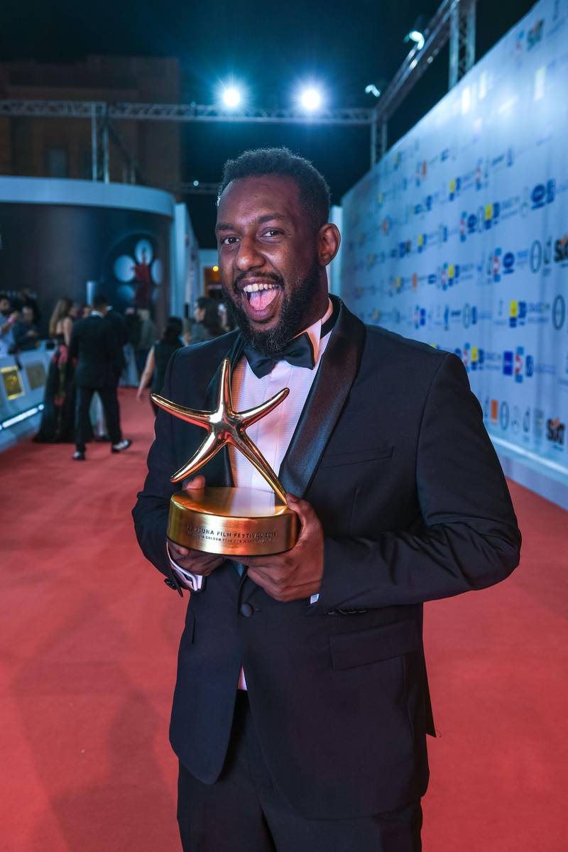 Sudanese director Amjad Abu Alala⁣ poses with his award for 'You Will Die at Twenty'. AFP