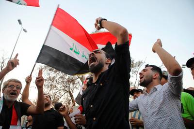 Demonstrators wave national flags and chant slogans during a demonstration demanding better public services and jobs in the southern city of Basra, Iraq, Tuesday, Sept. 25, 2018.  Masked gunmen shot dead Soad al-Ali, a human rights activist and mother of four, outside a supermarket in Basra on Tuesday, a brazen afternoon assassination that threatens to worsen tensions in the southern city wracked by violent protests. (AP Photo/Nabil al-Jurani)