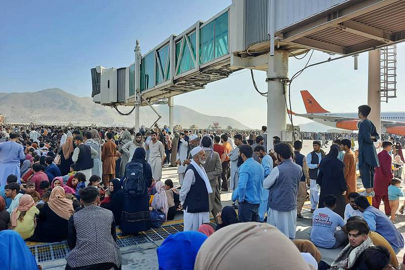 Afghans gather on the asphalt at Hamid Karzai International Airport, Kabul.