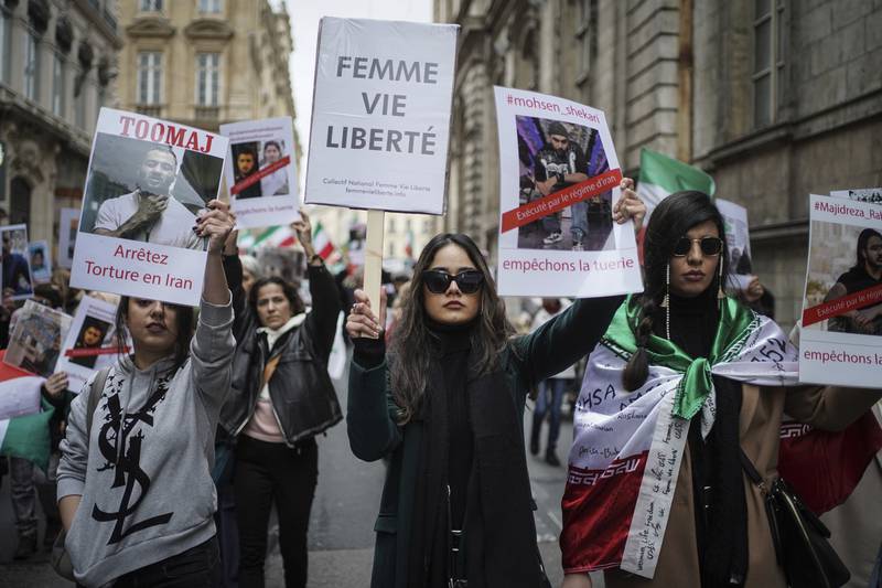 A protester holds a banner reading 'woman life freedom' in Lyon. AP