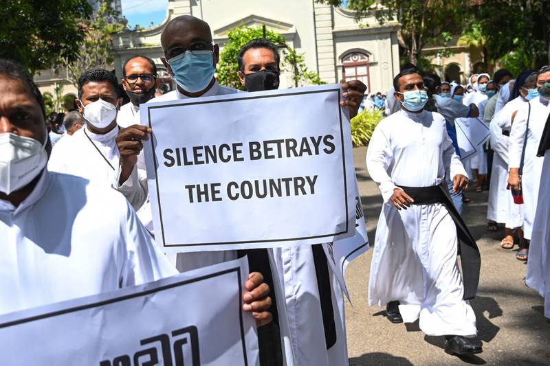 Catholic priests and sisters hold placards during a demonstration against the economic crisis in Colombo.