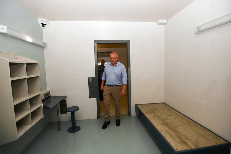 In this March 6, 2019, photo, Australian Prime Minister Scott Morrison walks into a high care accommodation room as he tours the North West Point Detention Centre on Christmas Island. Australia's government on Thursday, Jan. 30, 2020, defended its plan to send citizens evacuated from the epicenter of China's novel coronavirus emergency to the remote island used to banish asylum seekers and convicted criminals, despite warnings that that some Australians would prefer to stay in China. (Lukas Coch/AAP Image via AP)