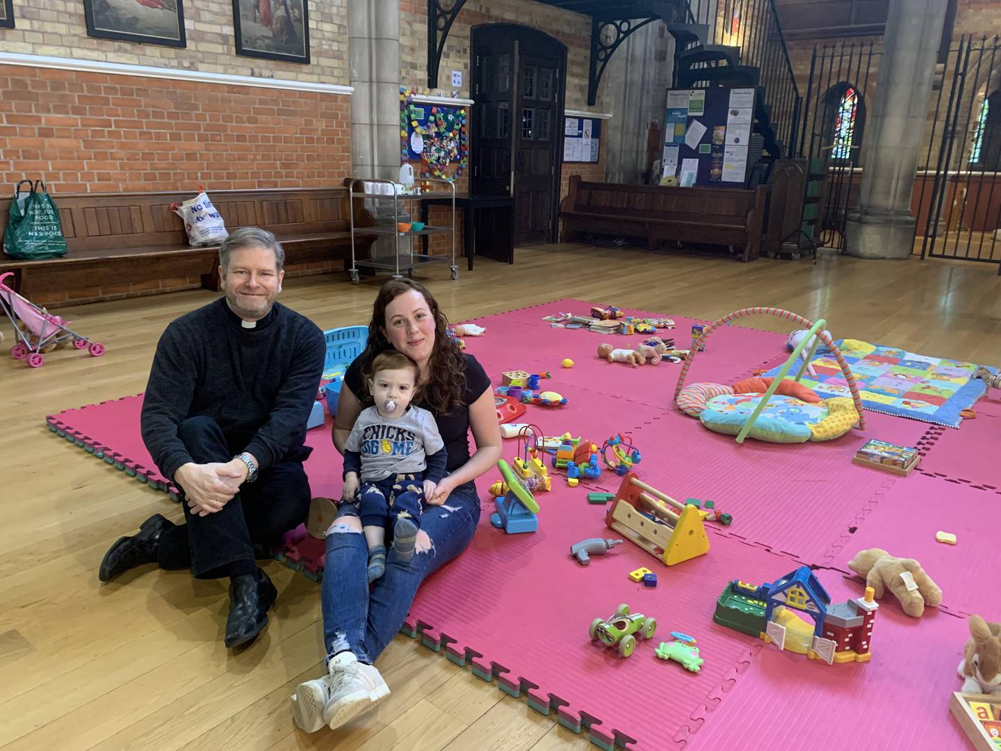Father Jonathan Kester, Anglican parish priest at Emmanuel Church in West Hampstead, with Hollie Thomas and her 21-month-old son Bobby Cooper. Father Kester and Ms Thomas welcomed the news that local woman Nazanin Zaghari-Ratcliffe had come home. Laura O'Callaghan / The National