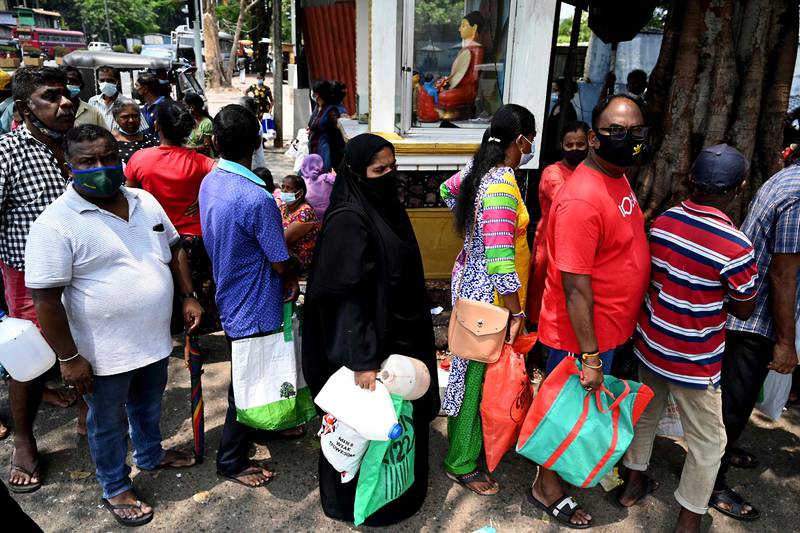 People queue to buy oil for home use at a petrol station in Colombo, Sri Lanka, amid surging prices and shortages. AFP