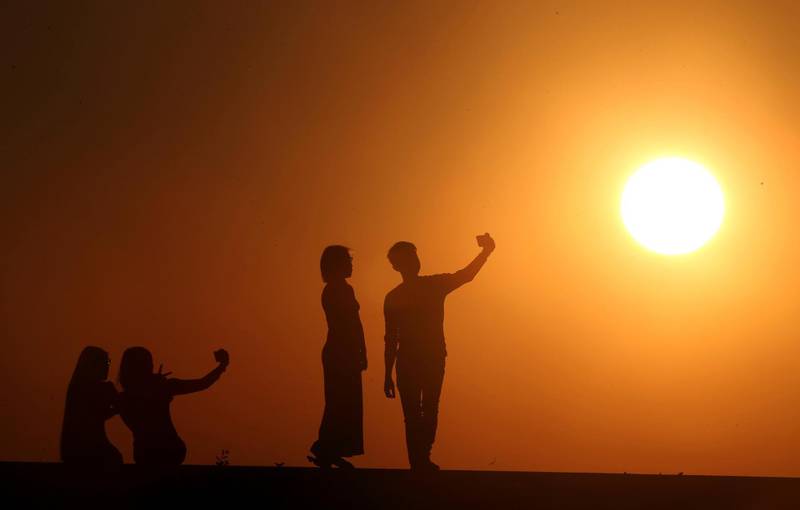 People take selfies during the last sunset of the year in Naypyitaw, Myanmar. AP Photo