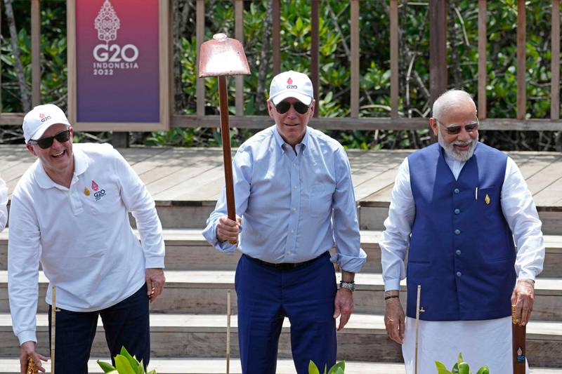 US President Joe Biden, centre, plants mangroves in Bali with Australian Prime Minister Anthony Albanese, left, and Indian Prime Minister Narendra Modi. AFP