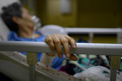 A Covid-19 patient keeps her hand on the bed railing at the ICU of the Ana Francisca Perez de Leon II public Hospital in Caracas, Venezuela. AP Photo