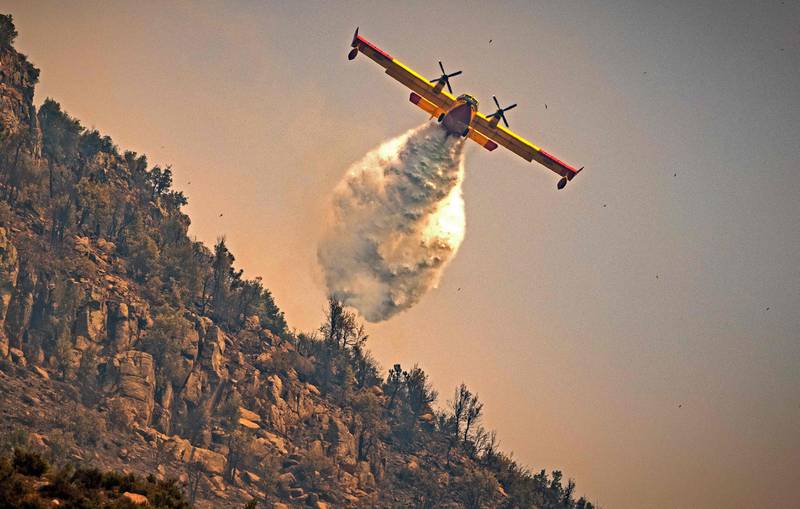 A Royal Moroccan Air Force Canadair plane douses a wildfire in the region of Chefchaouen, northern Morocco.