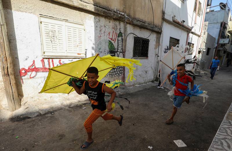 Palestinian children play in a street in the Amari refugee camp near the West Bank city of Ramallah on July 29, 2020. - A second wave of coronavirus infections sweeping the Israeli-occupied West Bank is fuelling fears of a surge in overcrowded Palestinian refugee camps where social distancing is widely seen as impossible. The Palestinian health ministry's Tuesday update logged more than 10,860 confirmed cases of infection since the start of the pandemic, including more than 75 deaths. (Photo by ABBAS MOMANI / AFP)