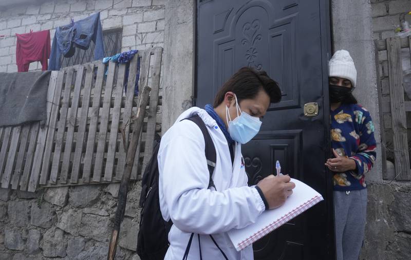 A doctor prescribes medicine for a person infected with Covid-19, in Quito, Ecuador. AP