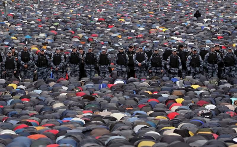 A police guard watches worshippers attending Eid morning prayers outside Central Sobornaya Mosque in Moscow, Russia. EPA 