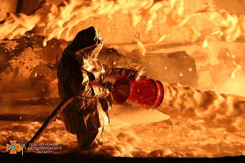 A Ukrainian firefighter works at the site of a burning fuel storage facility ignited by an air strike, in Dnipropetrovsk. Reuters