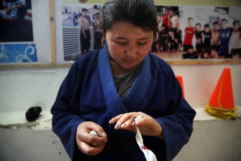 Jiu Jitsu club member Liqa Esazada looks at her injury practice during a training session in Kabul. AP