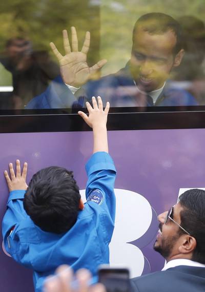 His sons and daughter shared a final moment together, pressing their hands against the class of the bus before the crew left for the launchpad. EPA