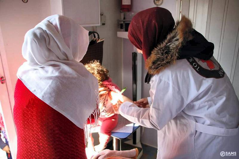 SAMS medical staff providing vaccines for a young patient in Idlib. Courtesy Hands Up Foundation