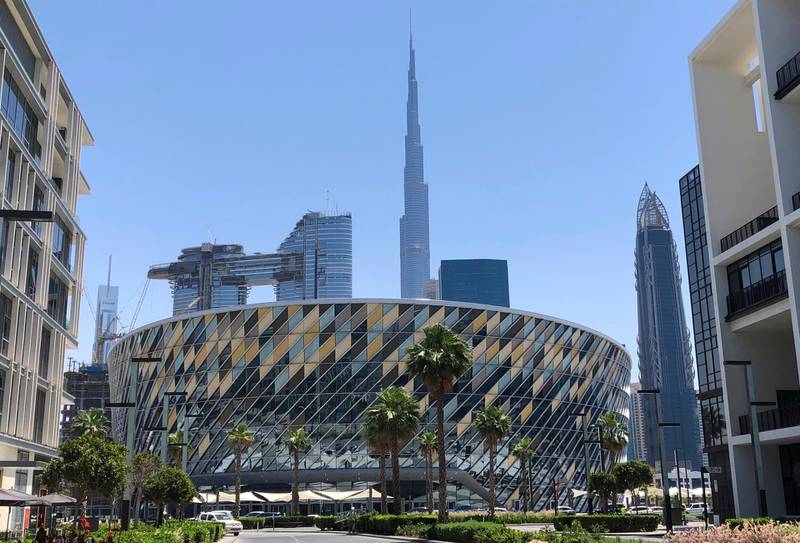 This Tuesday, April 16, 2019 photo shows the Coca Cola Arena  in front of world tallest building, Burj Khalifa, in Dubai, United Arab Emirates. Dubai unveils its latest mega-project, a stadium and arena in the heart of a super luxe shopping and dining destination, even as the economy slows down and thousands of jobs are being axed across the emirate. (AP Photo/Kamran Jebreili)