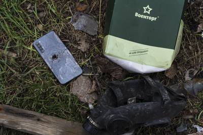 A smashed mobile phone lies next to a Russian army ration book in Bucha. AP