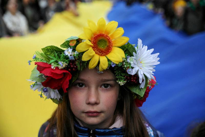 A young girl in front of people carrying a huge Ukrainian flag during a peaceful demonstration entitled 'Solidarity with Ukraine' in Krakow, Poland. Reuters