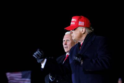 US President Donald Trump gestures next to Vice President Mike Pence, as he holds a campaign rally at Gerald R. Ford International Airport in Grand Rapids , Michigan, US, early November 3, 2020. Reuters
