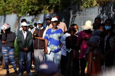 Social grant recipients stand in a queue outside a post office, as joblessness takes its toll in Meadowlands, South Africa. Reuters