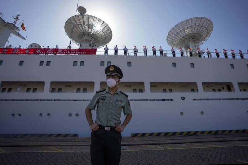A Chinese military officer stands on the quay at Hambantota, with the 'Yuan Wang 5' and crew members in the background. AP 