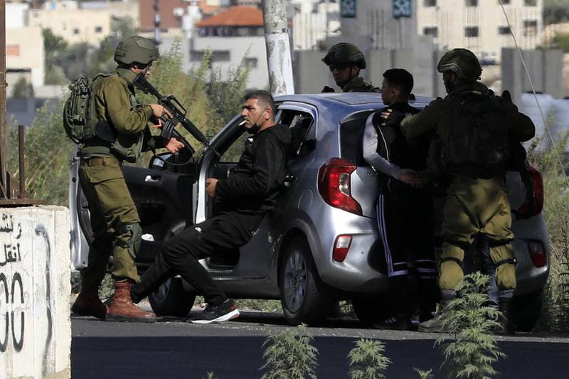 Israeli soldiers detain a Palestinian at a checkpoint in Hawara. AFP