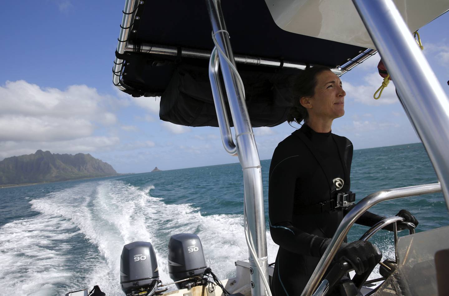 Kira Hughes, a coral researcher at the University of Hawaii's Institute of Marine Biology, drives a boat in Kaneohe Bay during a survey dive. Scientists are trying to speed up coral's evolutionary clock to build reefs that can better withstand the impacts of global warming. AP