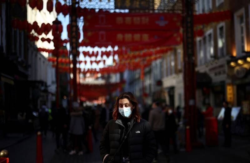 A person wearing a protective face mask as protection against coronavirus disease Covid-19 walks through Chinatown in London. Reuters