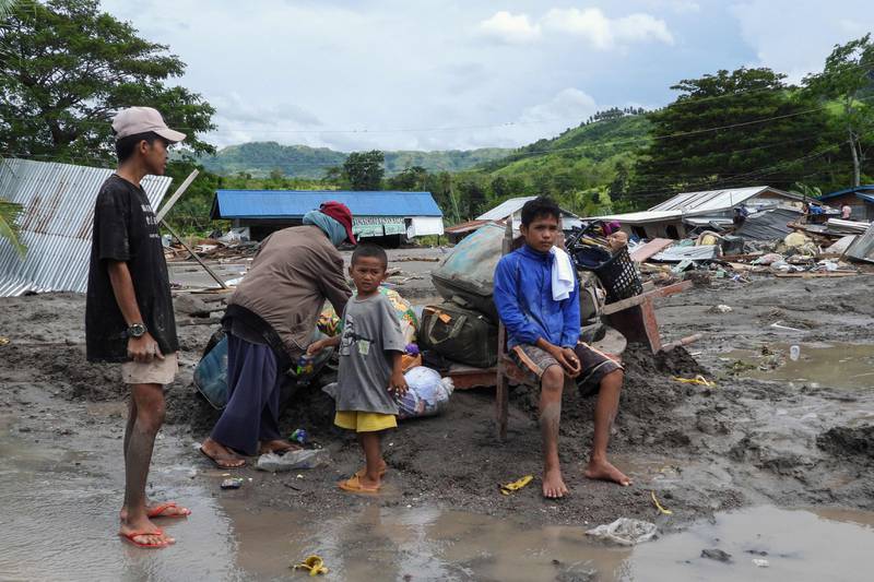 Residents outside their homes destroyed by a landslide in the village of Kusiong, in Datu Odin Sinsuat, southern Philippines. AFP